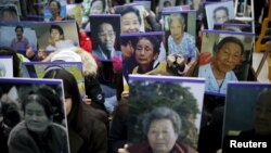 지난해 12월 30일 주한 일본대사관 앞에서 일본군 위안부 문제 해결을 요구하며 열린 수요 시위에서 학생들이 위안부 피해 할머니들의 사진을 들고 있다. (자료사진)