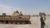 FILE - A Kurdish fighter holds his weapon as he stands near a tank in the Ghwairan neighborhood of Hasaka, Syria, Aug. 22, 2016. Recent days have seen renewed fighting between Kurdish and governments forces.