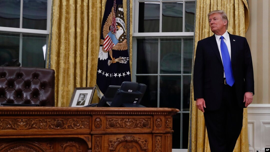 President Donald Trump pauses during a ceremony in Oval Office of the White House in Washington, Wednesday, Feb. 1, 2017, for the swearing in ceremony of Rex Tillerson as Secretary of State. (AP Photo/Carolyn Kaster)