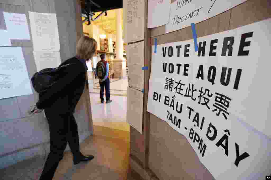 A woman peers into a polling station at the main branch of the public library, Boston, Massachusetts, Nov. 8, 2016.