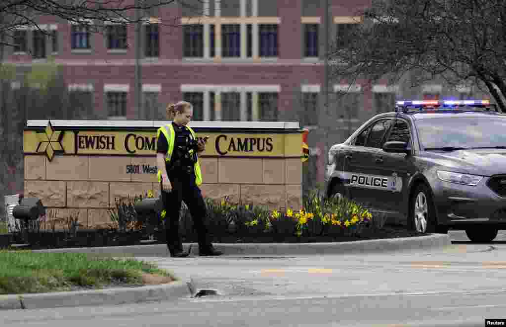 An Overland Park, Kansas police officer guards the entrance to the scene of a shooting at the Jewish Community Center of Greater Kansas City in Overland Park, Kansas, April 13, 2014.