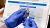 Nurse Kathe Olmstead prepares a shot as the world's biggest study of a possible COVID-19 vaccine, developed by the National Institutes of Health and Moderna Inc., gets underway Monday, July 27, 2020, in Binghamton, N.Y. (AP Photo/Hans Pennink)