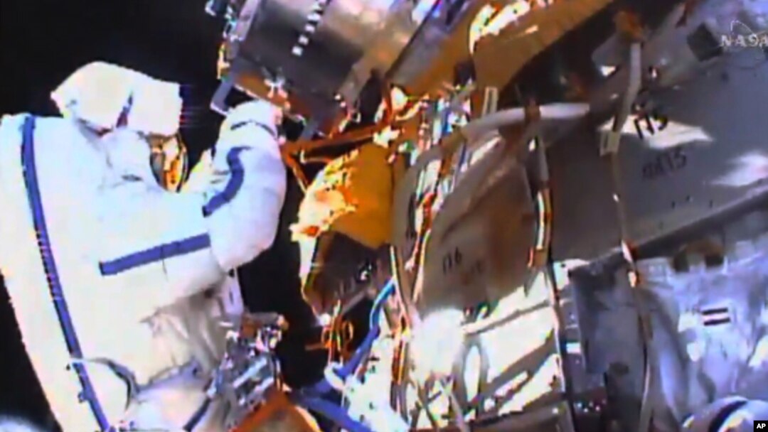 This photo taken from video provided by NASA shows Russian cosmonauts Yuri Malenchenko and Sergey Volkov install fresh experiments outside the International Space Station on Feb. 3, 2016.