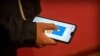 FILE - A person uses a smartphone app in an illustration photo taken March 18, 2020. South African organization Praekelt.org has gone global with a Whatsapp bot that raises awareness about the coronavirus.