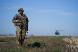 FILE - A Ukrainian serviceman secures an area in a government-controlled area of Donetsk region, eastern Ukraine, Oct. 14, 2019.