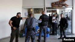 Israeli policemen stand at the scene of a Palestinian stabbing attack in Tel Aviv, Israel, Nov. 19, 2015.