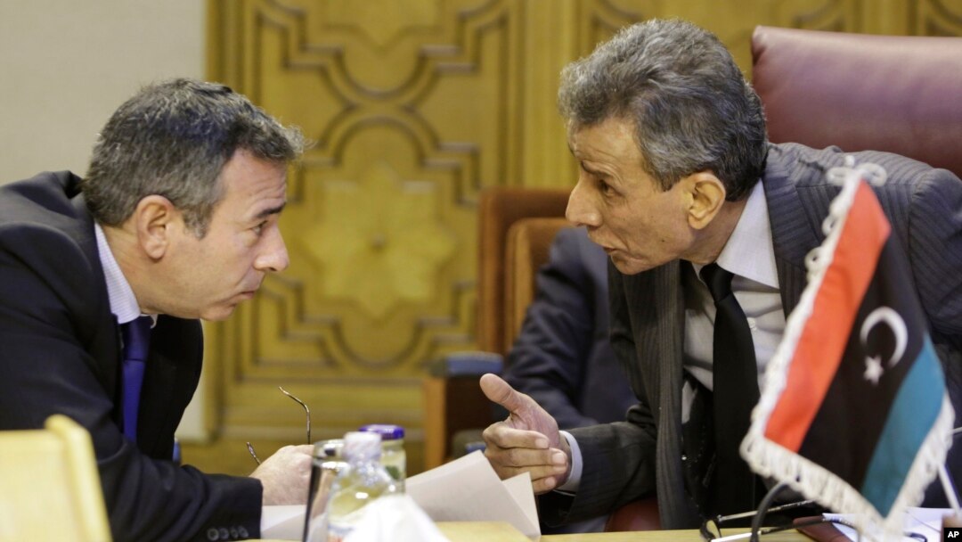 Ashour Abu-Rashed, right, Libyan representative at the Arab League, talks to his Egyptian counterpart, Tarek Adel, during an emergency meeting in Cairo to discuss the conflict in Libya, Jan. 5, 2015.
