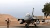 FILE - An Iraqi army soldier stands guard near a U.S.- made Iraqi air force F-16 jet at Balad Air Base, Iraq, Feb. 13, 2018 . Three rockets fired by militants hit the base June 14, 2019, in one of several attacks Iraqi authorities are investigating.