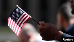Citizenship candidate holds flag 