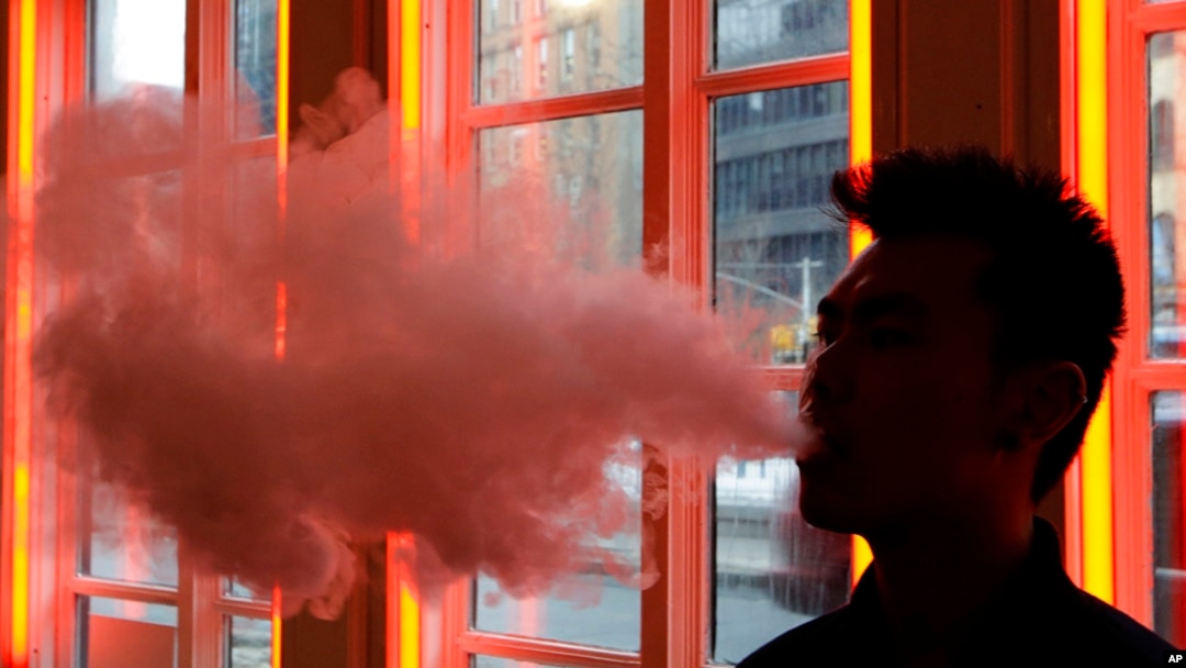 FILE - A patron exhales vapor from an e-cigarette at the Henley Vaporium in New York