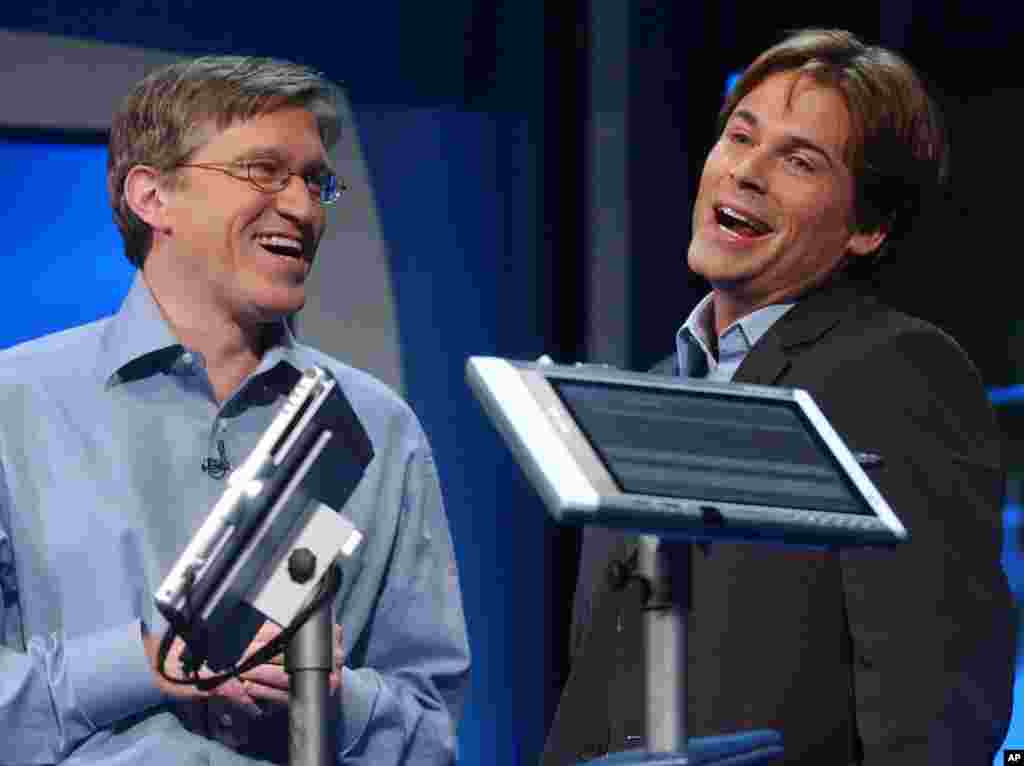 Jeff Raikes, group vice president of the Productivity and Business Systems Group at Microsoft (L) jokes with Actor Rob Lowe, as he describes his experiences using a Tablet PC at the product launch event in New York City, Nov. 7, 2002.