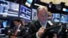 FILE - Trader Christopher Morie, right, works on the floor of the New York Stock Exchange.