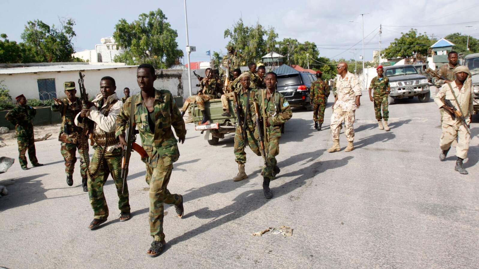 Somali soldiers patrol near the wreckage of a car bomb that was detonated at the main gate of the presidential palace in Mogadishu, Somalia, July, 9, 2014. 