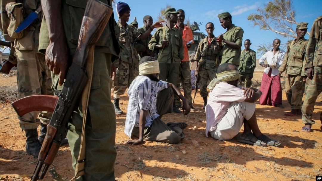Alleged members of al-Shabab are blindfolded and guarded by soldiers of the Somali National Army (SNA) in Kismayo, southern Somalia, Wednesday, Oct. 3, 2012.