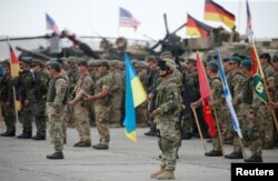 Servicemen from different countries stand at attention during an opening ceremony of the NATO-led military exercises "Noble Partner 2018" at Vaziani military base outside Tbilisi, Georgia, Aug. 1, 2018.