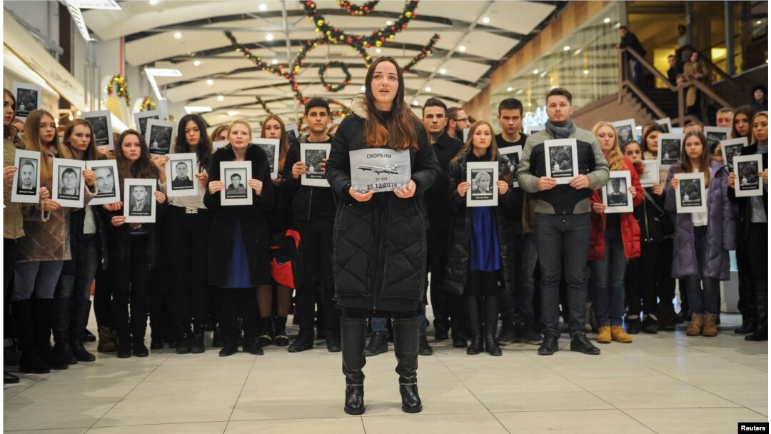 People hold portraits and printed names of victims of the Tu-154 plane, which crashed into the Black Sea on its way to Syria on Sunday, during a memorial event in Rostov-On-Don, Russia, Dec. 26, 2016.