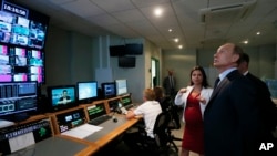 FILE - Russian President Vladimir Putin visits the headquarters of what was then known as the Russia Today television channel in Moscow, June 11, 2013 Major brands in the export division of Russian media include RT, the RIA Novosti news agency, Sputnik,