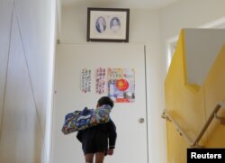 A student stops to bow to a portrait of Japanese former Emperor Hirohito and Empress Kojun at Tsukamoto kindergarten in Osaka, Japan, Nov. 30, 2016.
