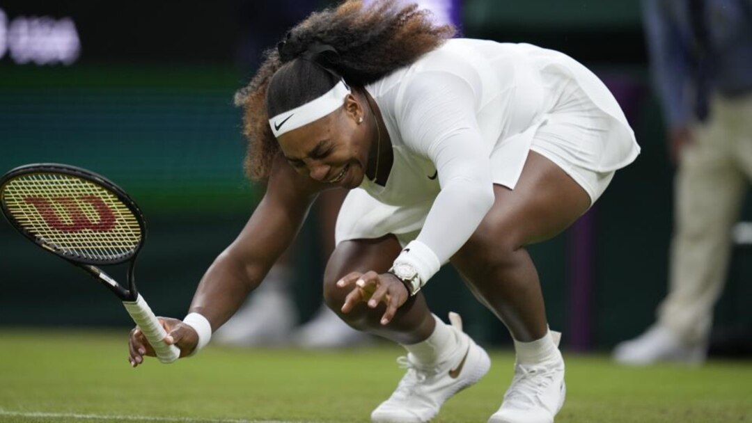 Serena Williams of the US falls to the ground during the women's singles first round match against Aliaksandra Sasnovich of Belarus on day two of the Wimbledon Tennis Championships in London, Tuesday June 29, 2021. (AP Photo/Kirsty Wigglesworth)