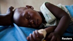 Young girl with malaria rests in a clinic in South Sudanese state of Nothern Bahr el Ghazal.