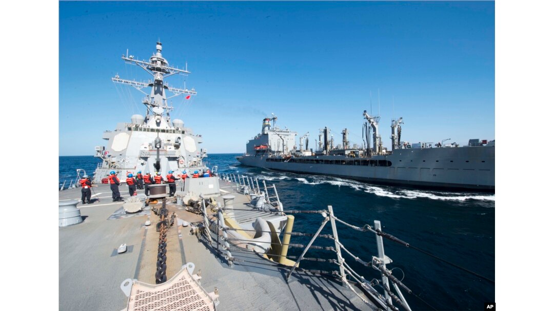 FILE - Guided-missile destroyer USS Bulkeley participates in a replenishment-at-sea with fleet replenishment oiler USNS John Lenthall in the Gulf of Oman. Iranian naval vessels conducted rocket tests last week near the USS Harry S. Truman aircraft carrier.