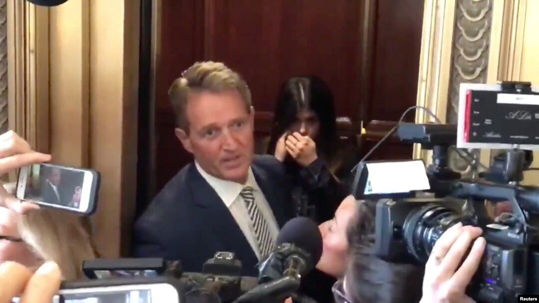 Senator Jeff Flake reacts during a confrontation with a protester in an elevator in Washington, D.C., Sept. 28, 2018 in this still image obtained from a social media video.