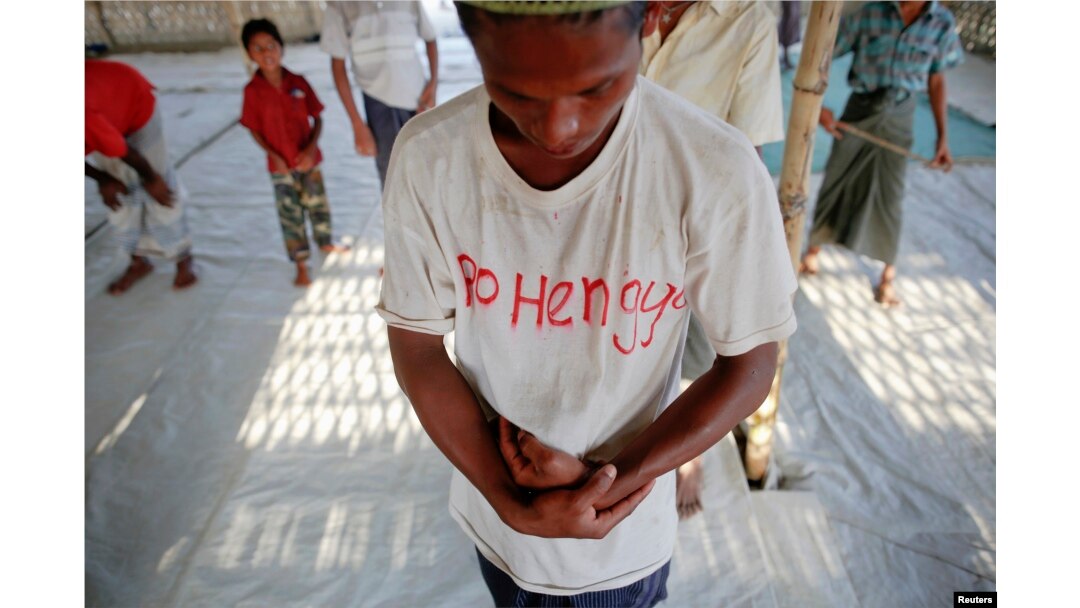 A Rohingya Muslim with the word "Rohingya" written on his T-shirt prays with others at a makeshift mosque at a camp for those displaced by violence, near Sittwe April 28, 2013.
