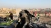 FILE - Debris is seen from an Ukrainian plane which crashed as authorities work at the scene in Shahedshahr, Iran, Jan. 8, 2020.