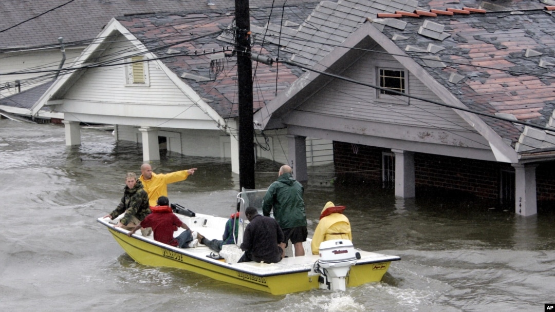 FILE - St. Bernard Parish Deputy Sheriff Jerry Reyes uses his boat to rescue residents after Hurricane Katrina hit the area causing flooding in their New Orleans neighborhood, Aug. 29, 2005.