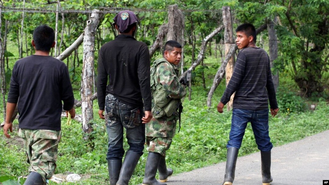ARCHIVO - Rebeldes de las Fuerzas Armadas Revolucionarias de Colombia (FARC) abandonan el área después de bloquear una carretera en El Palo, en el estado sureño de Cauca, Colombia, el martes 4 de junio de 2013.