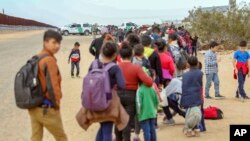 This Jan. 14, 2019, photo released by U.S. customs officials shows some of the 376 Central Americans arrested in Arizona for crossing into the United States illegally. They used holes dug under a barrier to cross in multiple spots about 10 miles east of San Luis, Ariz.