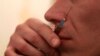 A man checks with his lips the temperature of a syringe with heroin injection at a flat in the Russian town of Tver, some 170 km (106 miles) northwest of Moscow, Nov. 13, 2010.