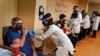 FILE - Staff members receive the COVID-19 vaccine at Holy Name Medical Center in Teaneck, N.J., Dec. 17, 2020.