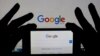 A smartphone and computer screen display the Google home page. U.S. presidential elections spur online searches for information about moving to Canada.