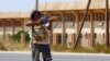 FILE - A fighter loyal to the U.N.-recognized Government of National Accord points his gun toward enemy lines during clashes with forces loyal to strongman Khalifa Haftar, in Espiaa, south of the Libyan capital, Tripoli, Aug. 21, 2019.
