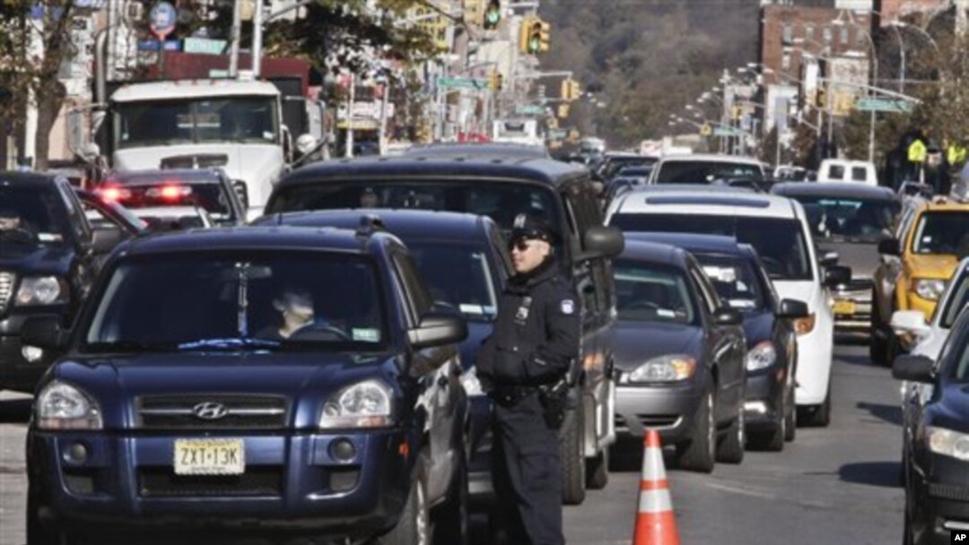 Police direct cars to gas pumps outside a gas station in the Brooklyn borough of New York, November 9, 2012.