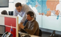 FILE - Opposition leader Alexei Navalny, standing, is seen at the office of his Anti-Corruption Foundation (FBK) in Moscow, March 18, 2018.