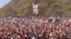 Supporters hold up a portrait of Zimbabwe Prime Minister Morgan Tsvangirai at his last campaign rally before elections set for Wednesday, in Harare, July, 29, 2013. 