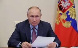 FILE - Russian President Vladimir Putin chairs a meeting with government members via a video conference call at Novo-Ogaryovo state residence outside Moscow, Russia, Feb. 10, 2021.