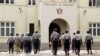 Zimbabwean police officers clear pamphlets left after a demonstration protesting delays in the drafting of a new constitution outside the parliament in Harare, Tuesday, Sept. 11, 2012. 