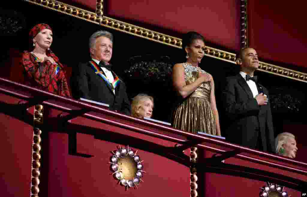El presidente Barack Obama y su esposa Michelle entonan el himno de EE.UU. durante la ceremonia de la entrega de premios a las artes del Kennedy Center. Acompa&ntilde;an a la pareja presidencial el actor Dustin Hoffman y la bailarina Natalia Makarova.