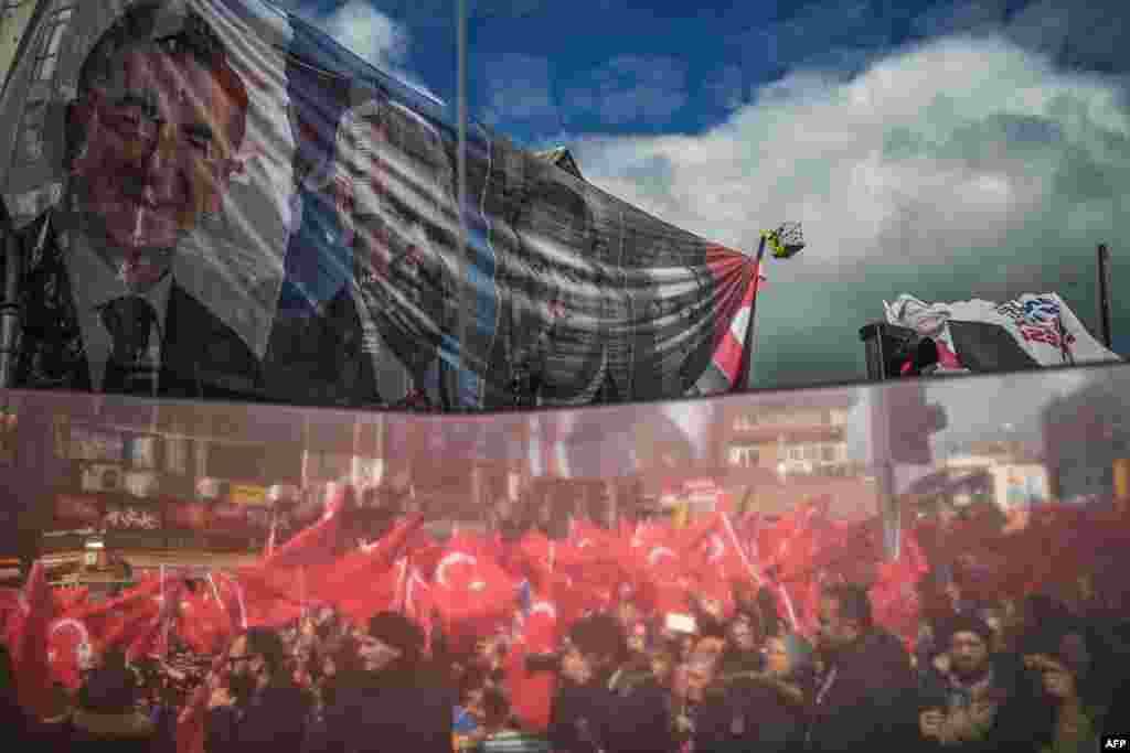 A reflection on a election bus window shows supporters of Turkey's Justice and development Party (AKP) during an election rally in Istanbul.