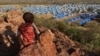 FILE - A boy sits atop a hill overlooking a refugee camp near the Chad-Sudan border on Nov. 9, 2023. A U.N. report released March 1, 2024, says the ongoing conflict in Sudan has resulted in the displacement of 8.1 million people.