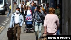 People walk down a street following the coronavirus disease (COVID-19) outbreak, London, July 29, 2020.