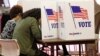 FILE - Voters fill out their ballots in the kiosks in Jackson, Miss., March 10, 2020.