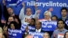 FILE - Supporters of Democratic presidential candidate Hillary Clinton hold signs and flags, March 22, 2016, during a campaign rally at Rainier Beach High School in Seattle, Wash.