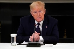 FILE - President Donald Trump listens during a meeting in the State Dining Room of the White House, May 18, 2020, in Washington.
