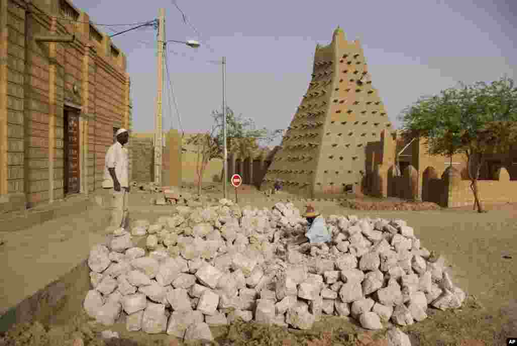 This May 1, 2012 photo shows men work near one of Timburktu's historic mud mosques.