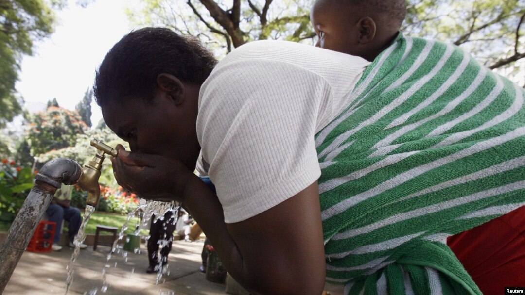 A Zimbabwean woman drinks water from a tap in Harare, May 4, 2010. 
