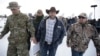 Ammon Bundy, center, one of the sons of Nevada rancher Cliven Bundy, walks off after speaking with reporters during a news conference at Malheur National Wildlife Refuge headquarters, Jan. 4, 2016, near Burns, Ore.